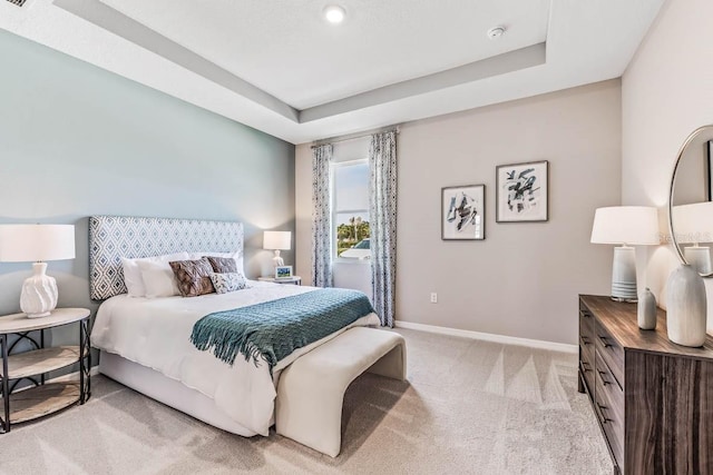 carpeted bedroom with a tray ceiling