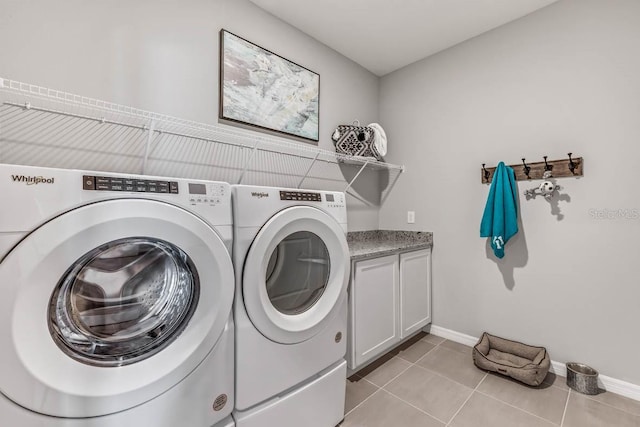 washroom featuring light tile patterned flooring, cabinets, and independent washer and dryer