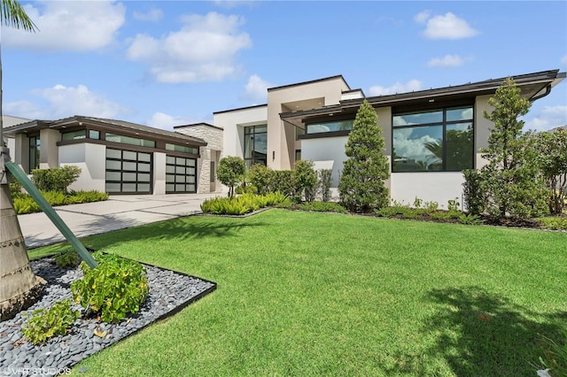 contemporary home featuring a garage and a front lawn