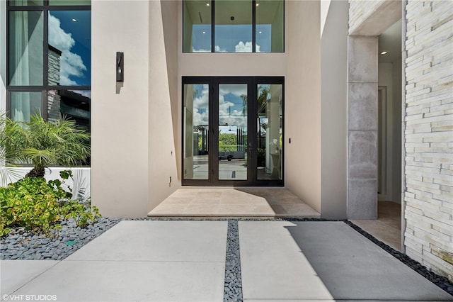 view of exterior entry with french doors and a patio area