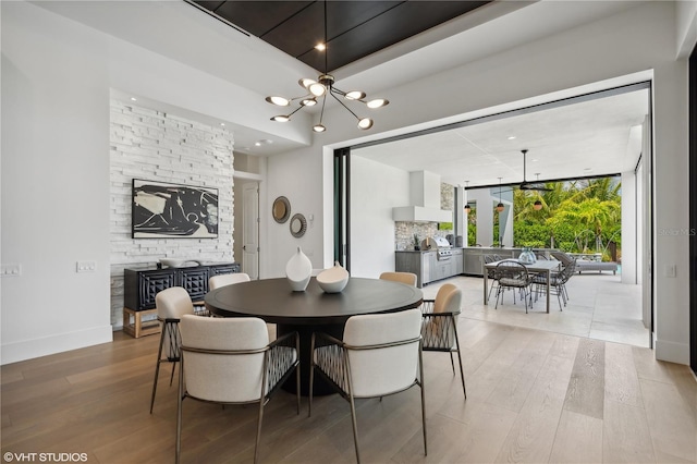 dining area featuring a wall of windows, light hardwood / wood-style floors, and a notable chandelier