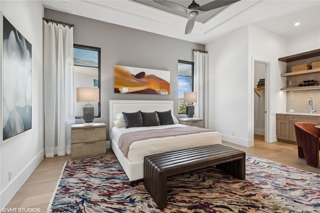 bedroom featuring ensuite bath, ceiling fan, and light hardwood / wood-style floors