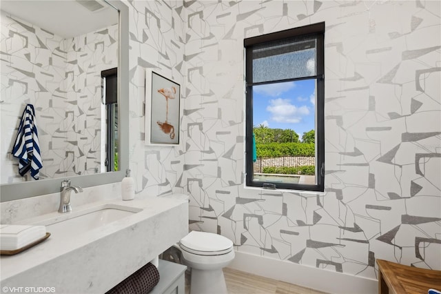 bathroom featuring wood-type flooring, toilet, tile walls, and sink