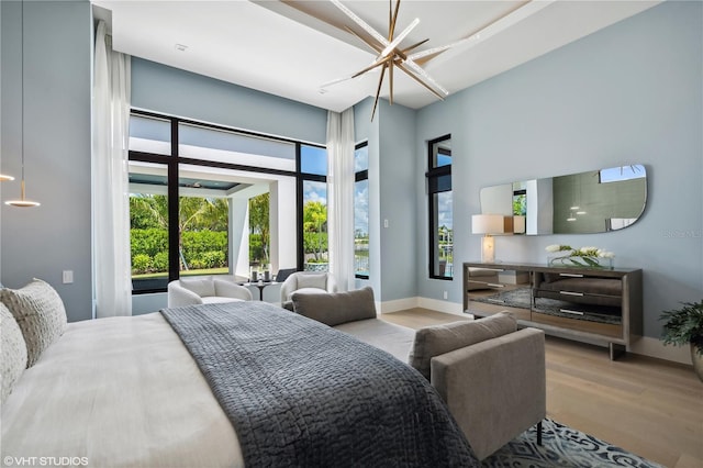 bedroom with hardwood / wood-style floors and ceiling fan with notable chandelier