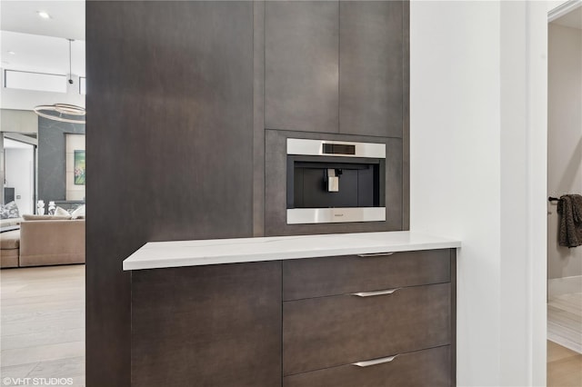 kitchen with light hardwood / wood-style flooring and dark brown cabinets