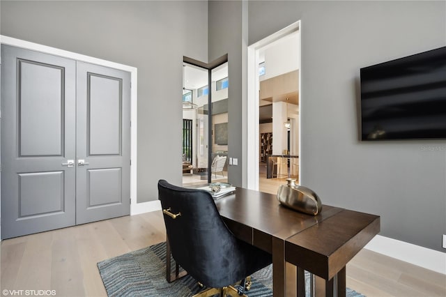 home office with light hardwood / wood-style flooring