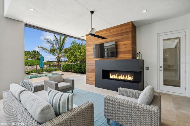 view of patio / terrace with ceiling fan and an outdoor fireplace