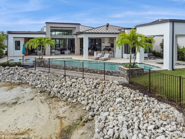 back of property featuring outdoor lounge area, a fenced in pool, and a patio area