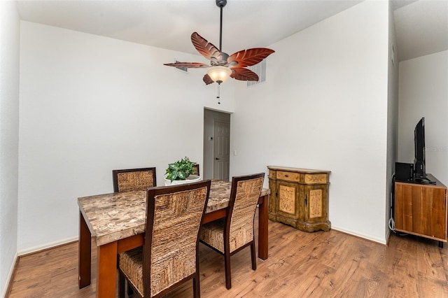 dining space with wood-type flooring, vaulted ceiling, and ceiling fan