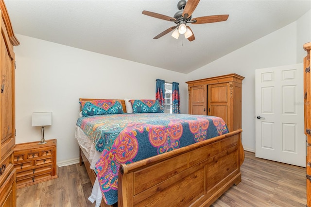 bedroom with ceiling fan, lofted ceiling, and hardwood / wood-style flooring