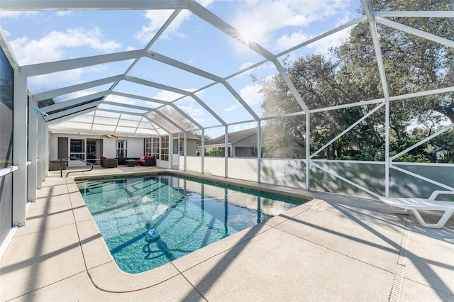 view of pool with ceiling fan, a patio area, and a lanai