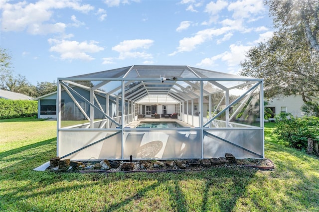 rear view of property with a lanai and a yard