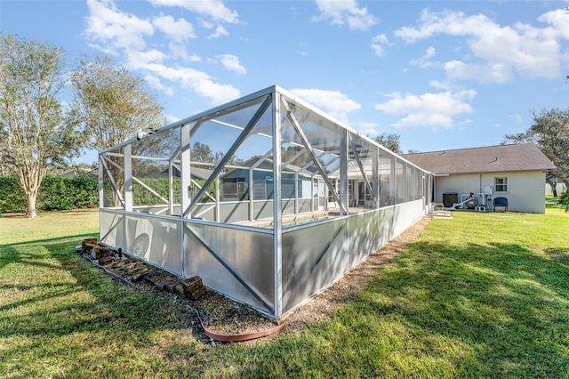 exterior space with a lawn and glass enclosure