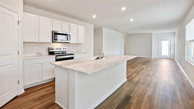 kitchen with white cabinetry, sink, dark hardwood / wood-style flooring, a kitchen island with sink, and appliances with stainless steel finishes