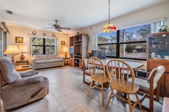 dining space featuring light tile patterned floors, a textured ceiling, and ceiling fan