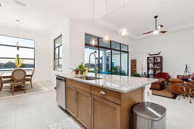 kitchen featuring light stone counters, ceiling fan, sink, decorative light fixtures, and dishwasher