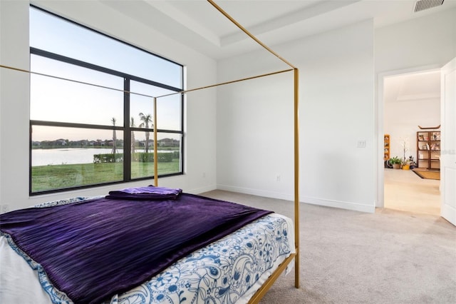 bedroom with a water view and light colored carpet