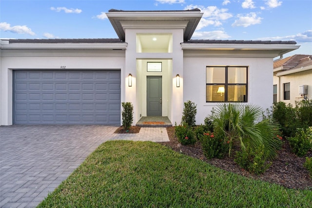 9132 Bernini Pl, Sarasota, FL 34240 - view of front of house with decorative driveway, stucco siding, a garage, and a front lawn
