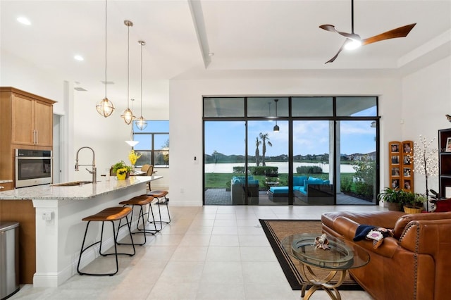 9132 Bernini Pl, Sarasota, FL 34240 - living room featuring ceiling fan, light tile patterned floors, baseboards, recessed lighting, and a water view