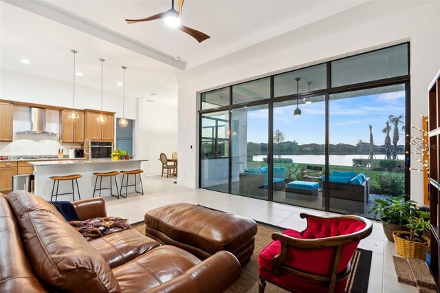 9132 Bernini Pl, Sarasota, FL 34240 - living room with light tile patterned floors, a ceiling fan, a water view, and recessed lighting