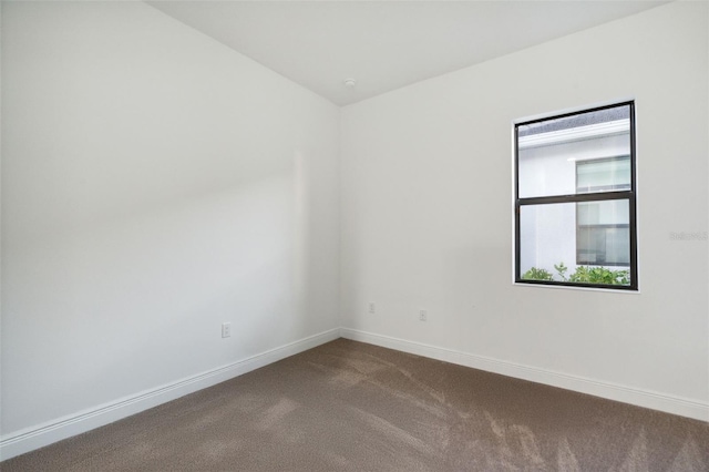 9132 Bernini Pl, Sarasota, FL 34240 - empty room featuring dark colored carpet and baseboards