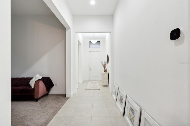 9132 Bernini Pl, Sarasota, FL 34240 - corridor featuring light tile patterned floors, baseboards, and light carpet