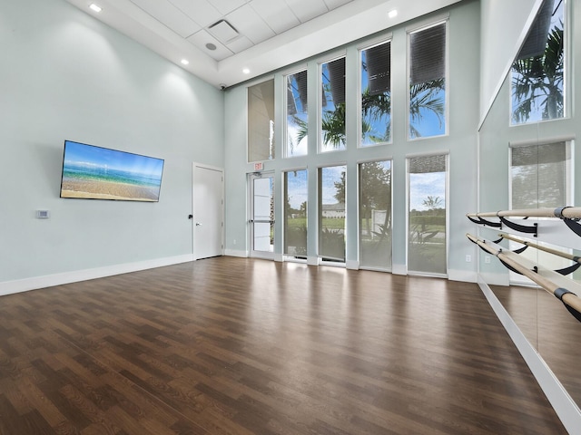 9132 Bernini Pl, Sarasota, FL 34240 - unfurnished living room featuring a high ceiling, plenty of natural light, wood finished floors, baseboards, and recessed lighting