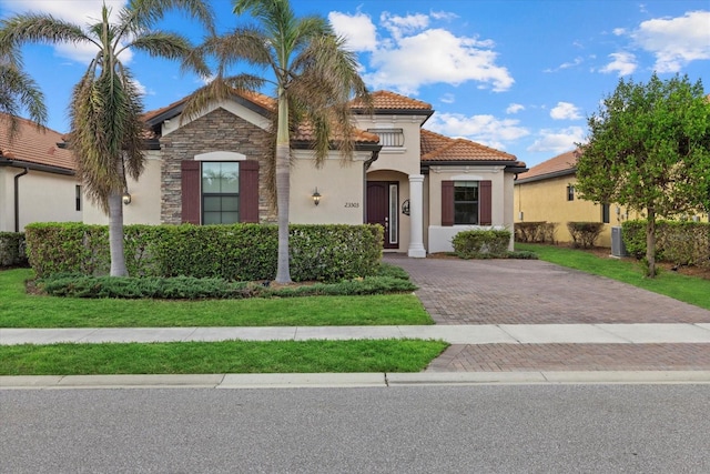 mediterranean / spanish-style home with a front yard