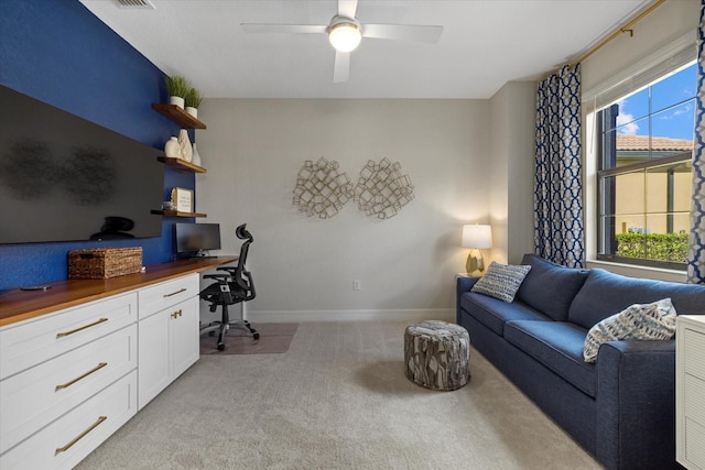 carpeted home office featuring ceiling fan