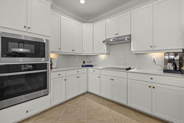 kitchen with white cabinetry, backsplash, appliances with stainless steel finishes, light tile patterned floors, and ornamental molding