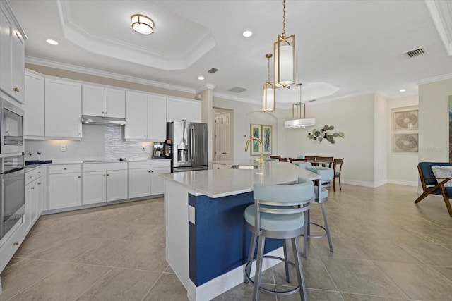 kitchen with sink, hanging light fixtures, stainless steel appliances, crown molding, and an island with sink