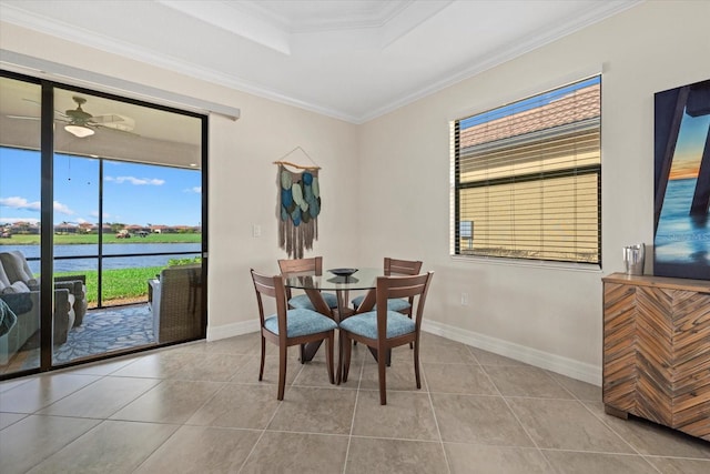 tiled dining room featuring a water view, ceiling fan, and ornamental molding