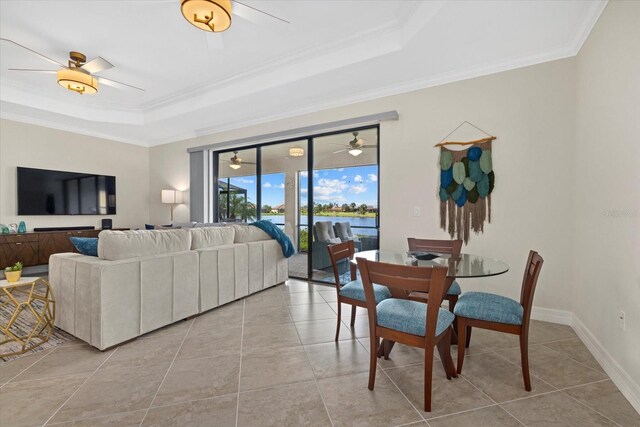 23503 Waverly Cir, Venice, FL 34293 - living area with a tray ceiling, ornamental molding, a ceiling fan, light tile patterned floors, and a water view