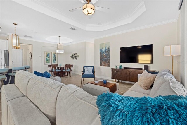 23503 Waverly Cir, Venice, FL 34293 - living room with a tray ceiling, crown molding, a ceiling fan, light tile patterned flooring, and baseboards