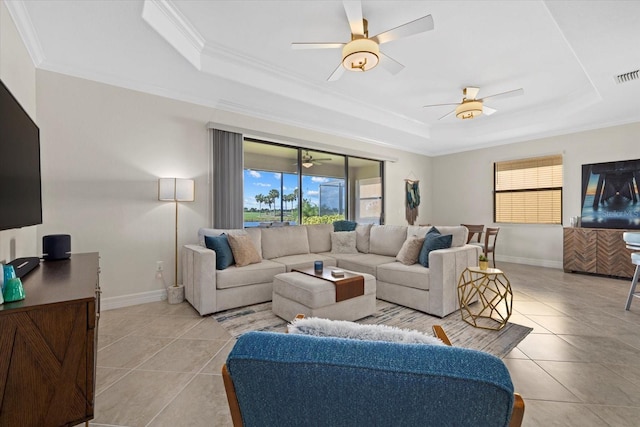 tiled living room featuring a tray ceiling and ornamental molding