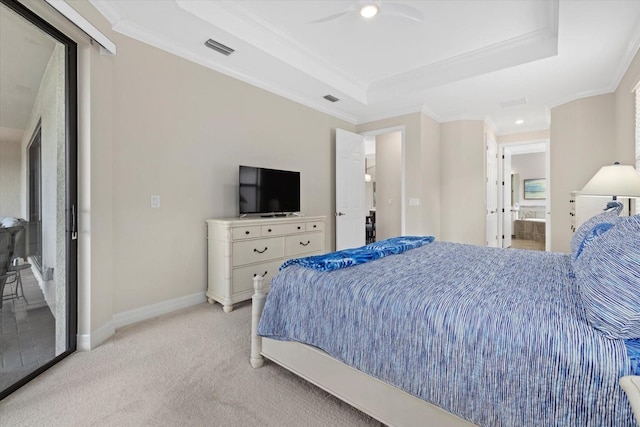 bedroom featuring light carpet, ensuite bath, ceiling fan, ornamental molding, and a tray ceiling