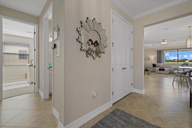 corridor with crown molding and light tile patterned floors