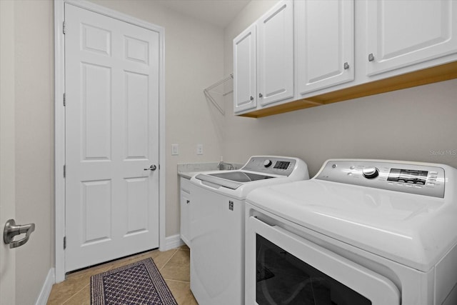 laundry area featuring cabinets, washer and clothes dryer, and light tile patterned flooring