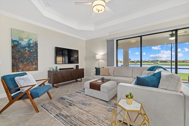 tiled living room featuring a tray ceiling, ceiling fan, and ornamental molding