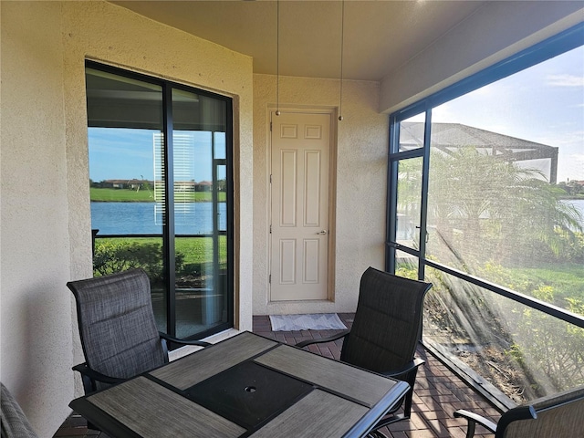 sunroom featuring a water view and plenty of natural light