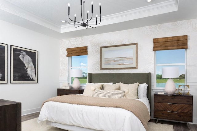 bedroom with hardwood / wood-style flooring, a notable chandelier, crown molding, and a tray ceiling