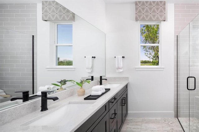 bathroom with vanity, a healthy amount of sunlight, and a shower with door