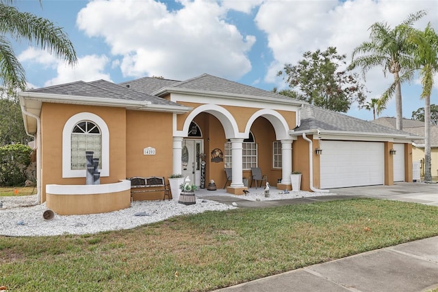 mediterranean / spanish home with a porch, a garage, and a front lawn