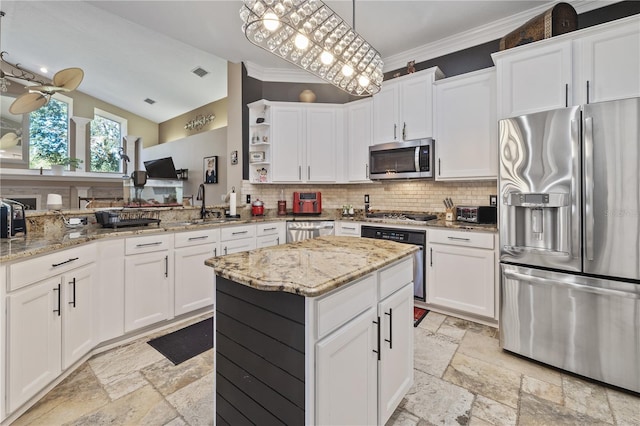 kitchen with appliances with stainless steel finishes, decorative light fixtures, white cabinetry, and crown molding