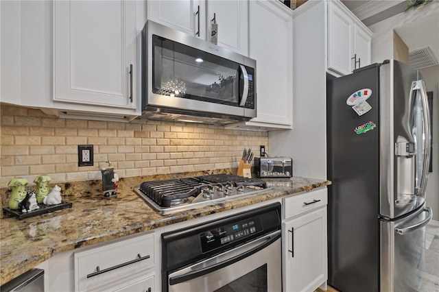 kitchen with light stone countertops, white cabinets, and appliances with stainless steel finishes