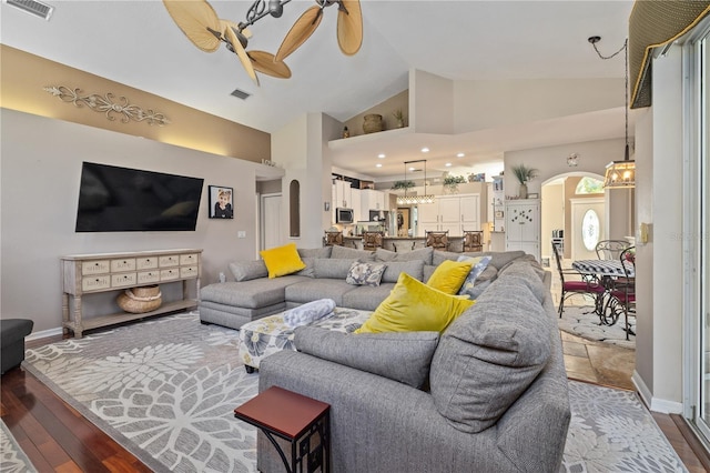 living room with ceiling fan, hardwood / wood-style floors, and high vaulted ceiling