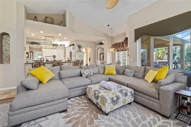 living room with ceiling fan, a healthy amount of sunlight, and high vaulted ceiling