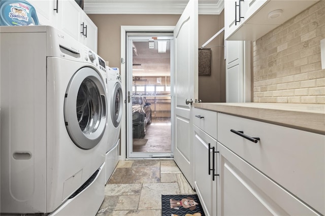 laundry room featuring washing machine and dryer, crown molding, and cabinets