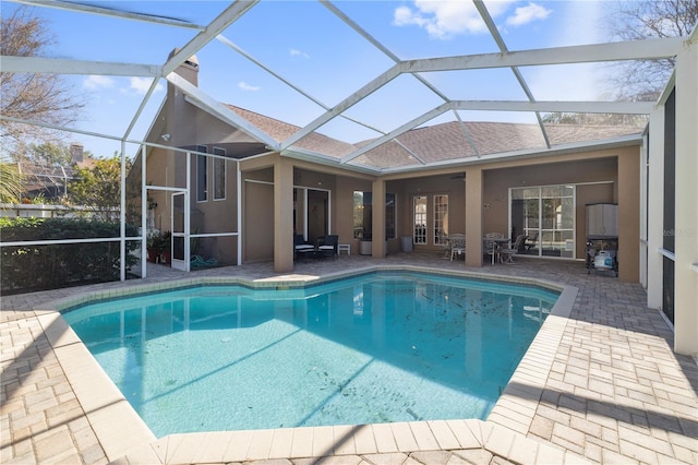 view of pool with glass enclosure, french doors, and a patio