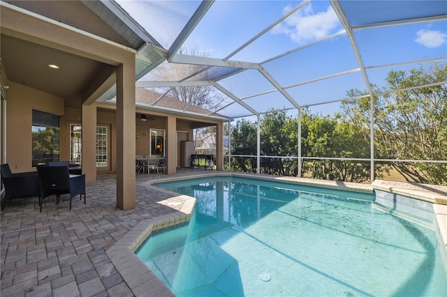 view of pool featuring ceiling fan, a patio, and glass enclosure